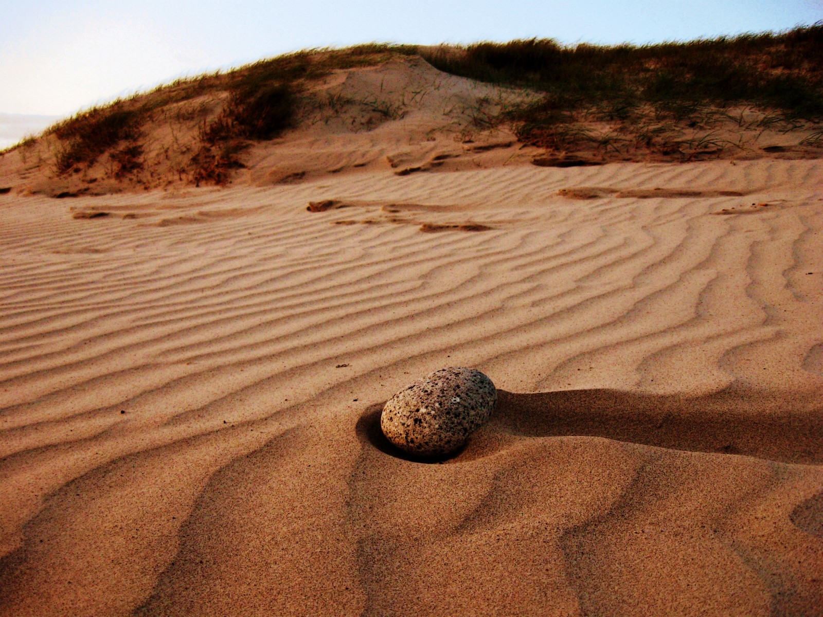 Relva, o céu, areia, pedra, dunas