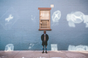 boots, coat, direct look, hat, jeans, lips, male, wall